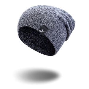 Detailed knit texture of grey striped beanie featuring crown logo patch for winter wear