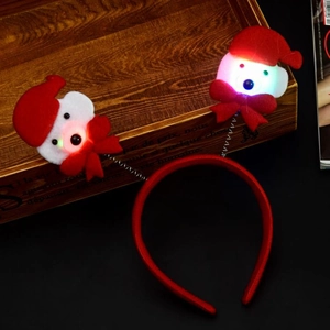 Detail of luminous Santa dolls on red velvet Christmas headband with glowing LED lights