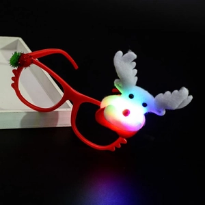 Close-up of glowing reindeer Christmas glasses with red frame and plush decoration