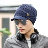 Detail view of navy blue knitted beanie with brim and vintage shield metal badge