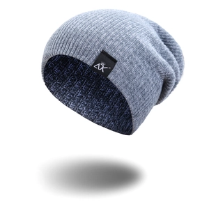 Close-up of light gray knit beanie with black AK crown logo label on white background
