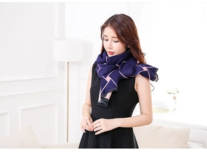 Detailed close-up of dark blue and pink geometric knit scarf texture worn by a model
