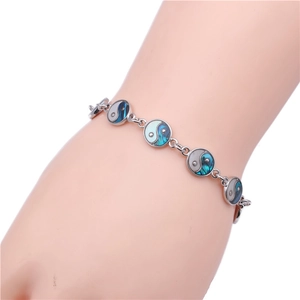 Silver Tai Chi Yin Yang bracelet with abalone shell inlays on female wrist