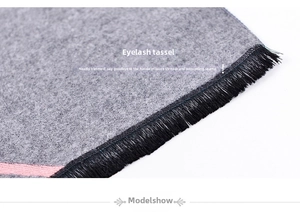 Close-up of grey scarf fabric with eyelash fringes and delicate pink stripes detail