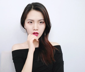 Close-up of a model wearing elegant long gold bar drop earrings in a minimalist style