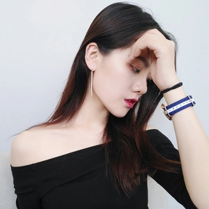 Minimalist silver long bar drop earrings shown on model with striped watch accessory