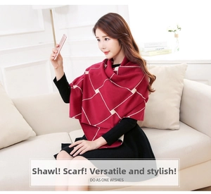 Detail of a thick burgundy and cream plaid shawl worn over the shoulders on a sofa