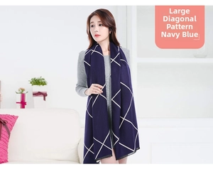 Detail of navy and beige oversized checkered warm scarf worn by a female model