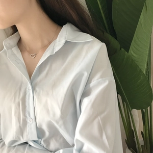 Detail of zircon heart pendant necklace worn on neck with elegant silver O-chain