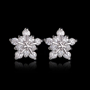 Close-up of sparkling snowflake stud earrings with AAA zircon inlay on black background