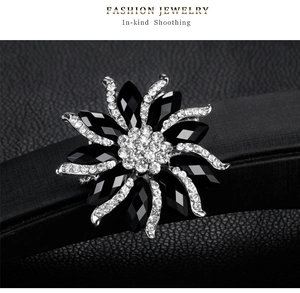 Close-up of floral brooch with black resin stones and sparkling silver crystals