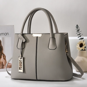 Detail of grey lychee pattern tote bag with gold metal trim and stylish shoulder strap