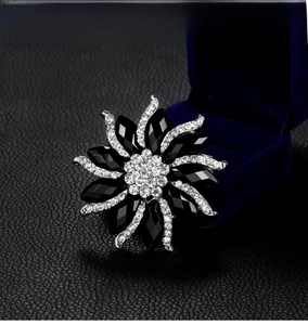 Detailed view of flower brooch with black stones and crystals on velvet jewelry box