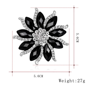 Detail of silver flower brooch with black resin stones and rhinestones showing 5.6cm dimensions