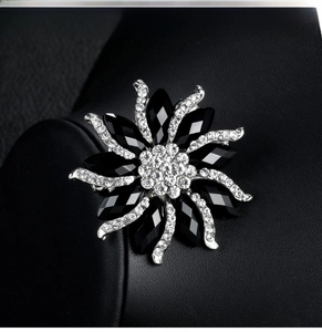 Macro shot of fashion flower brooch with black resin petals and sparkling crystals