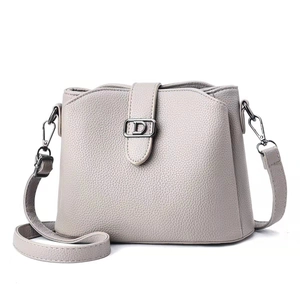 Minimalist light gray pebbled leather crossbody bag for women with silver D-buckle closure
