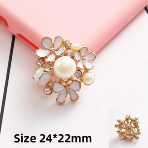 Detail showing pearl flower charm with gold base, white petals and rhinestones, size 24x22mm