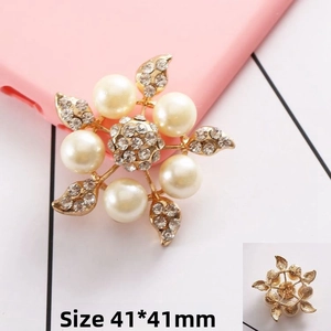 Detailed macro view of a 41mm pearl and crystal floral accessory with golden metal base