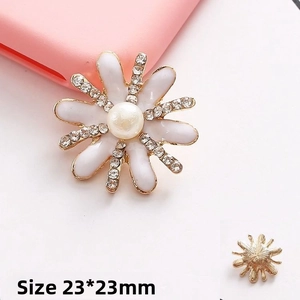Macro detail of daisy flower DIY charm with white enamel, pearl center and small rhinestones
