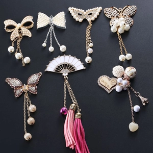 Close-up of assorted charms featuring pearls, tassels, and intricate metal butterfly designs