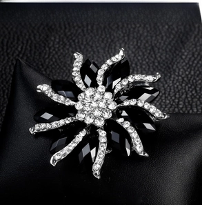Macro shot of a floral brooch featuring black marquise gems and sparkling rhinestones