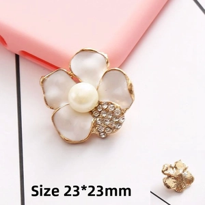 Macro detail of a 23x23mm pearl camellia flower charm with inlaid rhinestones and metal base