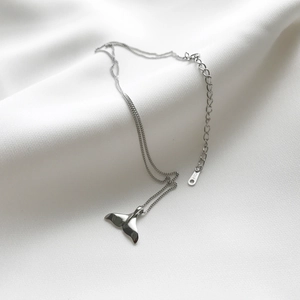 925 sterling silver dolphin tail pendant necklace on elegant white silk background