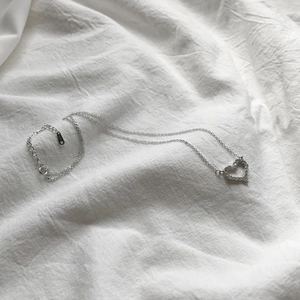 Elegant 925 sterling silver heart pendant necklace with zircon stones on white fabric