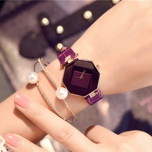 Close-up of purple octagonal watch with pearl and crystal bracelets on a wrist