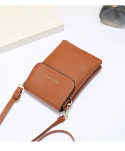 Detail of a brown leather mini crossbody bag with gold buckle and brand logo
