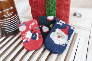 Close-up of three pairs of festive knit Christmas socks with Santa and snowflake patterns