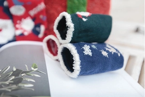 Detail of warm Christmas socks with sherpa lining featuring Santa and reindeer patterns