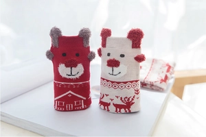 Detailed view of knitted Christmas socks featuring reindeer and bear cartoon designs