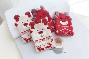 Detail of four festive Christmas socks with 3D bear ears and reindeer patterns on a desk