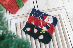 Detailed view of three pairs of cotton Christmas socks in festive gift box packaging