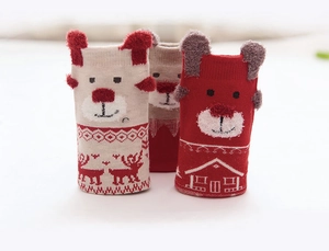 Detail of Christmas themed knit baby socks with reindeer patterns and 3D bear ears