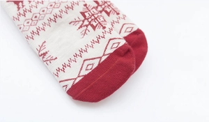Close-up of red and beige knitted Christmas socks with snowflake and geometric patterns