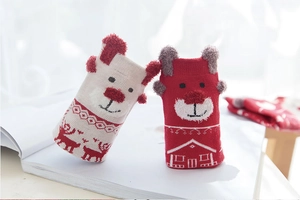 Detail of warm knitted baby socks featuring cute cartoon bear and festive reindeer patterns