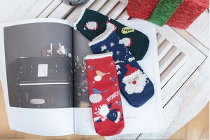 Close-up of festive cotton Christmas socks with Santa elk patterns and fleece cuffs