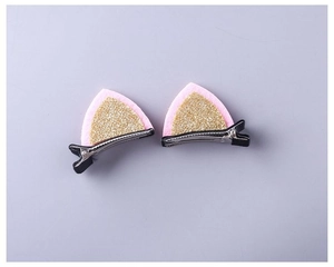 Close-up of pink and gold glitter cat ear hair clips with felt texture and metal grip