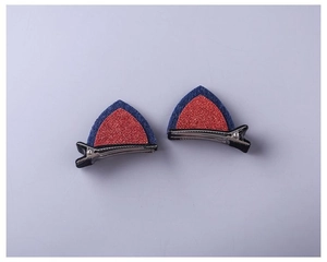 Close-up of cat ear hair clips with blue felt and red glitter sequins on metal duckbill clips