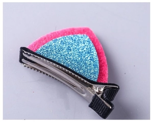 Macro shot of rose pink felt cat ear hair clip with blue sequins on black metal clip