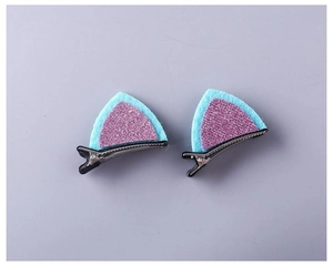 Detail of sequined cat ear hair clips with blue felt and purple glitter on a metal base