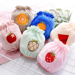 Detail of plush fruit drawstring pouches including strawberry and pineapple in a basket