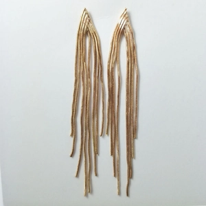Detailed view of long gold tassel earrings with sleek cascading metal snake chains