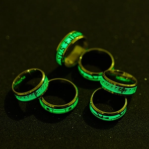 Detail of glow-in-the-dark luminous music rings set with green fluorescent music notes