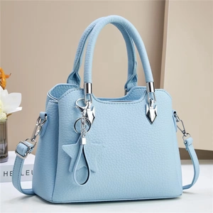 Detail of light blue bucket bag with pebble leather texture and silver star pendant