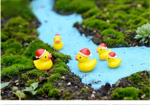 Detail of five mini Christmas resin ducks on moss landscape for DIY micro gardens