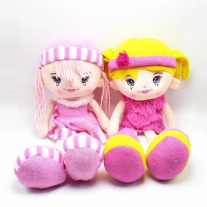 Close-up of two plush dolls in pink and yellow outfits with fine embroidery details
