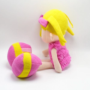 Detail of cute doll featuring yellow yarn hair and pink sequined plush dress from back view